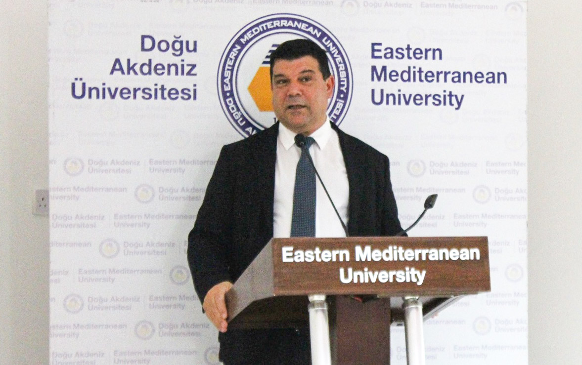 Speaker at the podium with the EMU backdrop