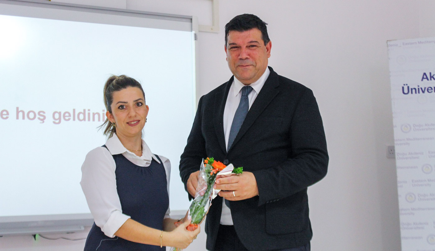 A woman and a man on stage with a bouquet of flowers
